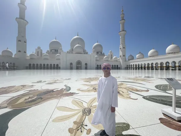 A young man posing in front of the Grand Mosque in Abu Dhabi thumbnail