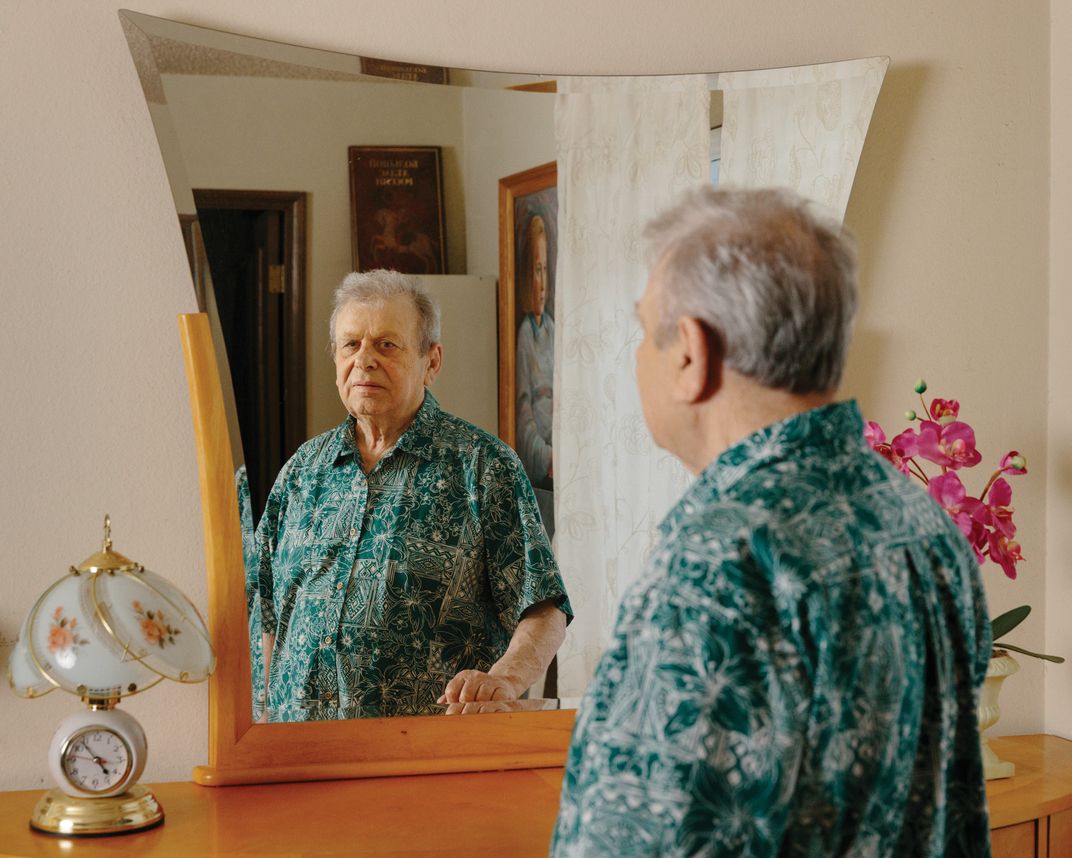 a man in front of mirror stands for a portrait