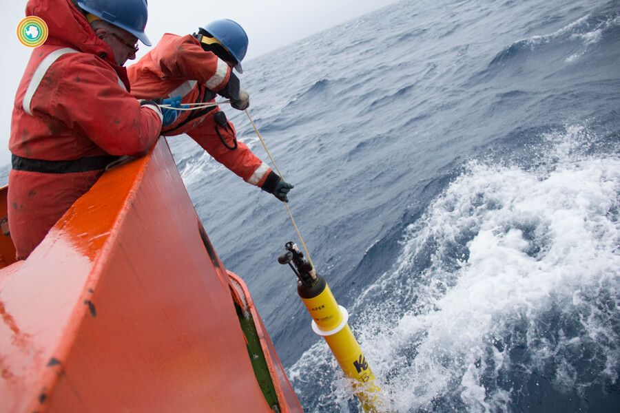 Researchers lean over side of boat with device to measure CO2