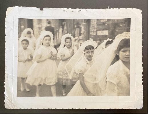 Photograph of a group of girls in the first communion waiting in line.