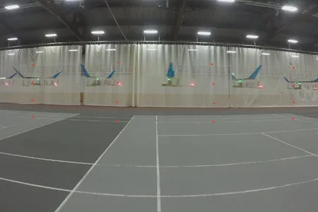 A time-lapse image showing the plane flying across a gymnasium. 