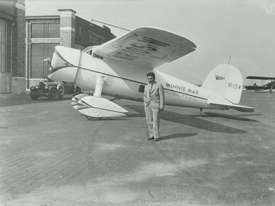 Aviator Wiley Post under the wing of the Winnie Mae (1933). 