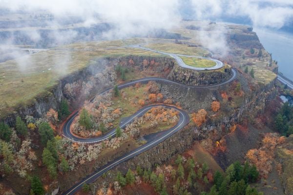 Stunning Aerial View of Curved Road Leading to a Plateau in Fall Colors thumbnail