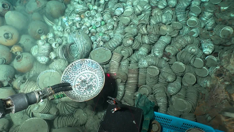 Robot arm grabbing a piece of pottery underwater