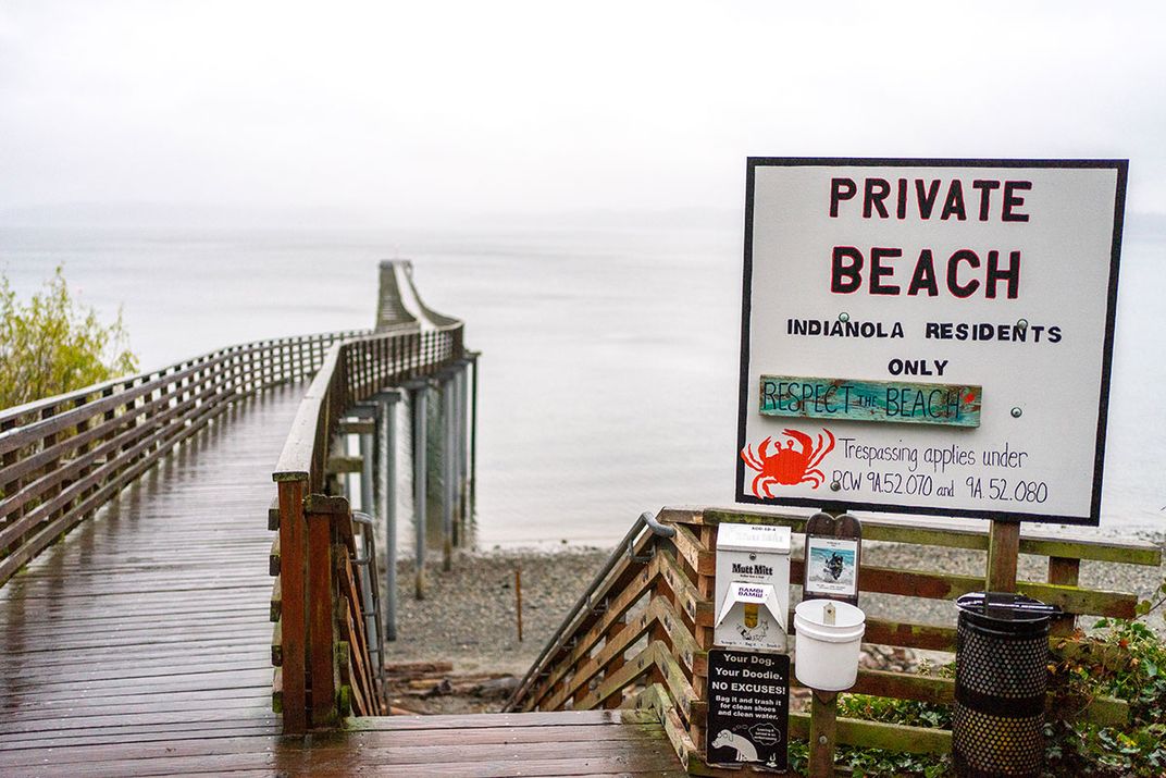 A sign in front of a dock stretching out into the water reads: PRIVATE BEACH. INDIANOLA RESIDENTS ONLY.
