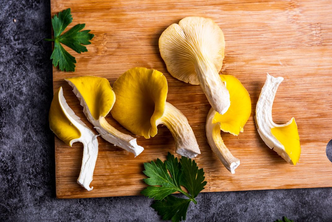 golden oyster mushrooms on a cutting board