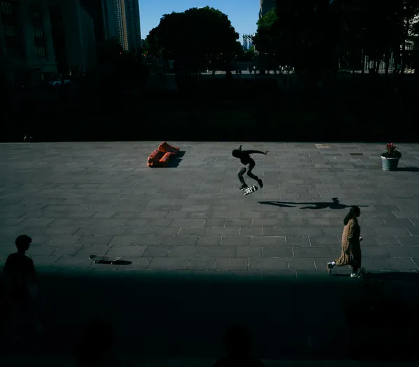 Skateboarder in NYC public plaza at dusk thumbnail