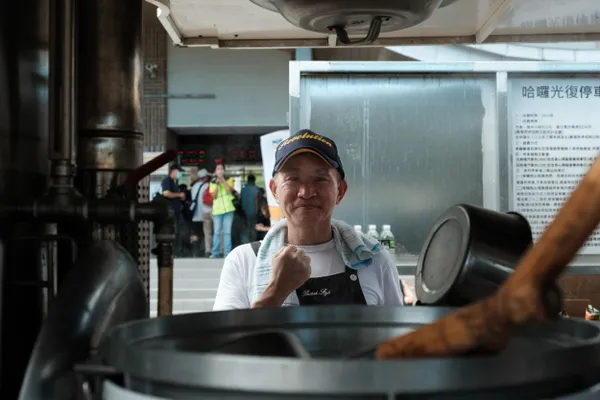 A mobile kitchen worker adds oil. thumbnail