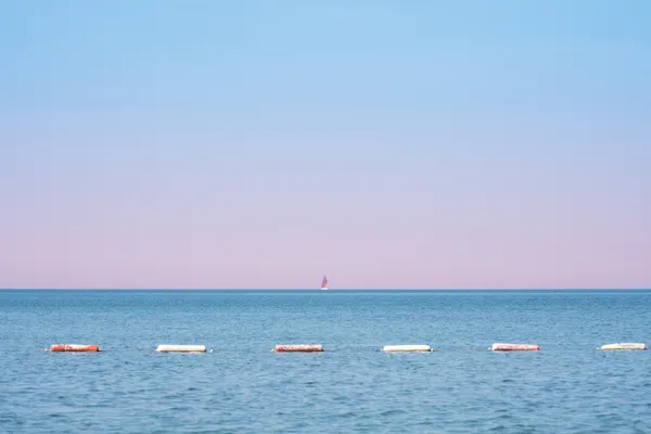 A sail boat on the horizon at Valdanos beach thumbnail