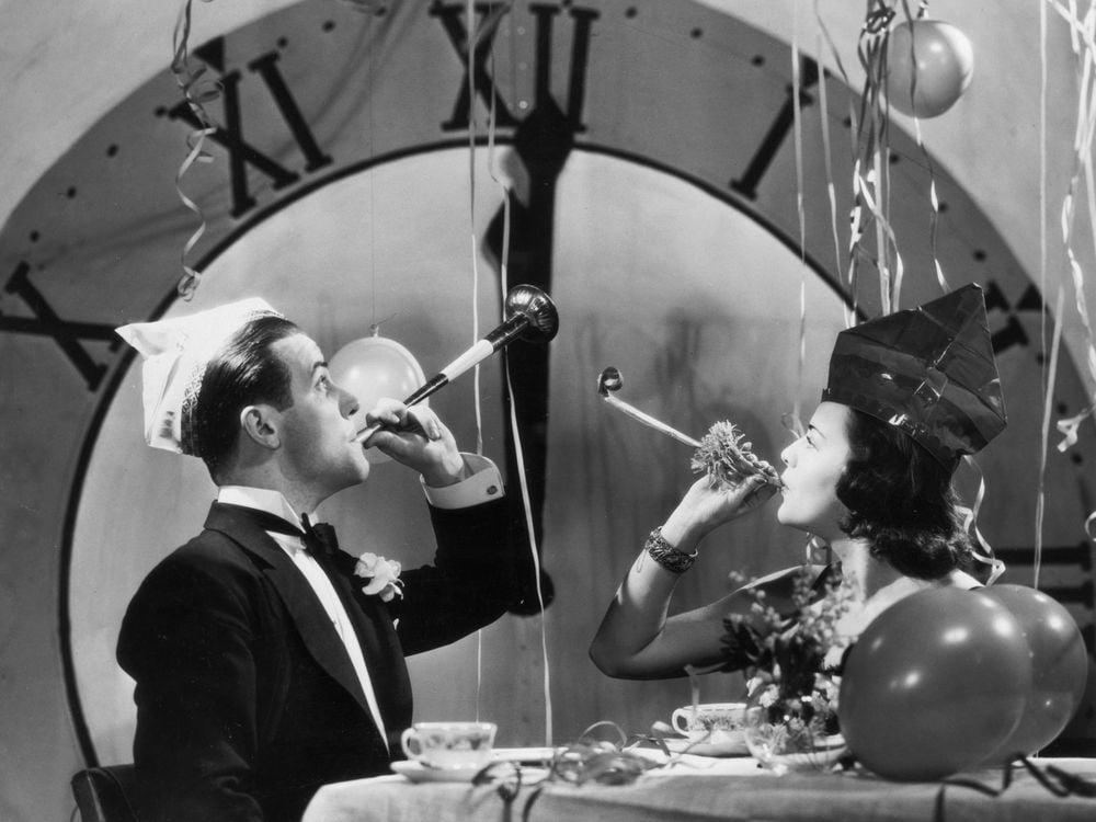 A couple rinsg in the New Year with party blowers and streamers, circa 1930