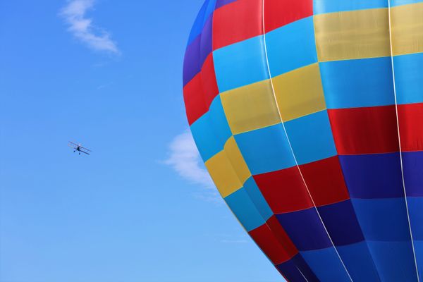 Balloons and planes adorn the sky at air show. thumbnail