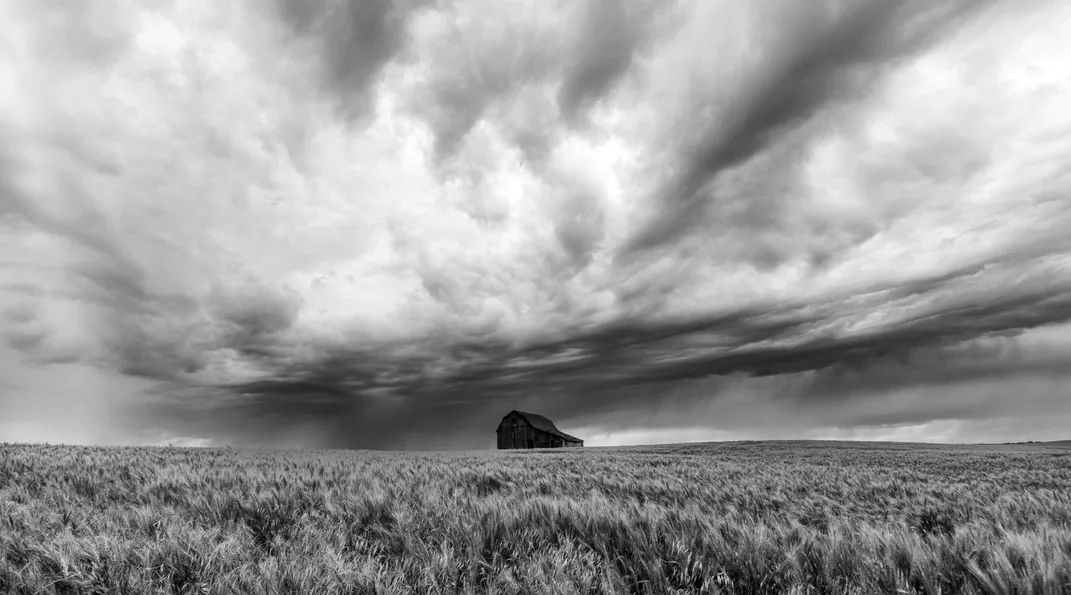 5 - Standing alone in an open field, an old barn seemingly steels itself for an approaching storm.