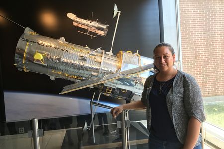 Astronomy intern Danielle Rowland stands with a model of the Hubble Space Telescope at the Space Telescope Science Institute in Baltimore.