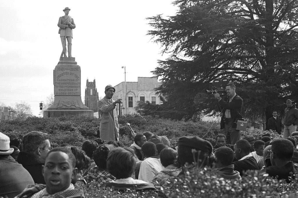 Tuskegee history professor Frank Toland speaks to the gathered students at the base of the Confederate monument
