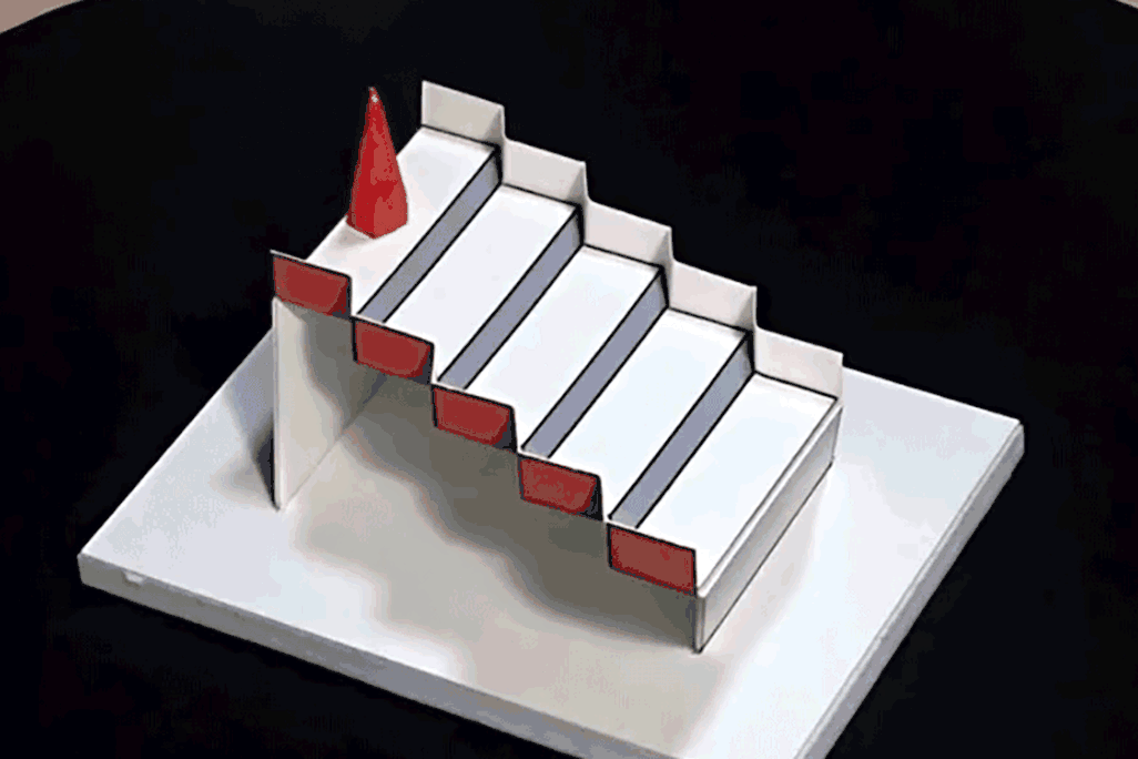 Animated image shows someone spin a staircase illusion so that it looks like a cone placed at the top of a staircase is now at the bottom 
