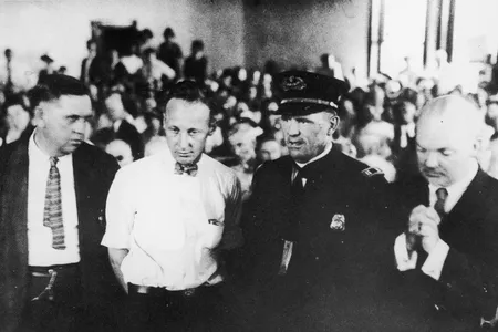 Teacher John T. Scopes (second from left) stands in the courtroom during his trial for teaching Darwin&rsquo;s theory of evolution in his high school science class.