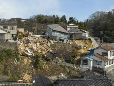 Damaged houses, one collapsed completely, along a street in Wajima, Japan, on January 2, 2024&mdash;one day after a 7.5 magnitude earthquake struck the region.