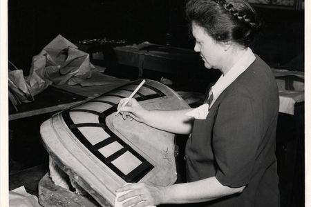 A woman marks a bombardier enclosure for a B-24 Liberator bomber at the Ford Willow Run plant.