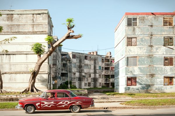Car Driving Past Apartment Block in Havana, Cuba thumbnail