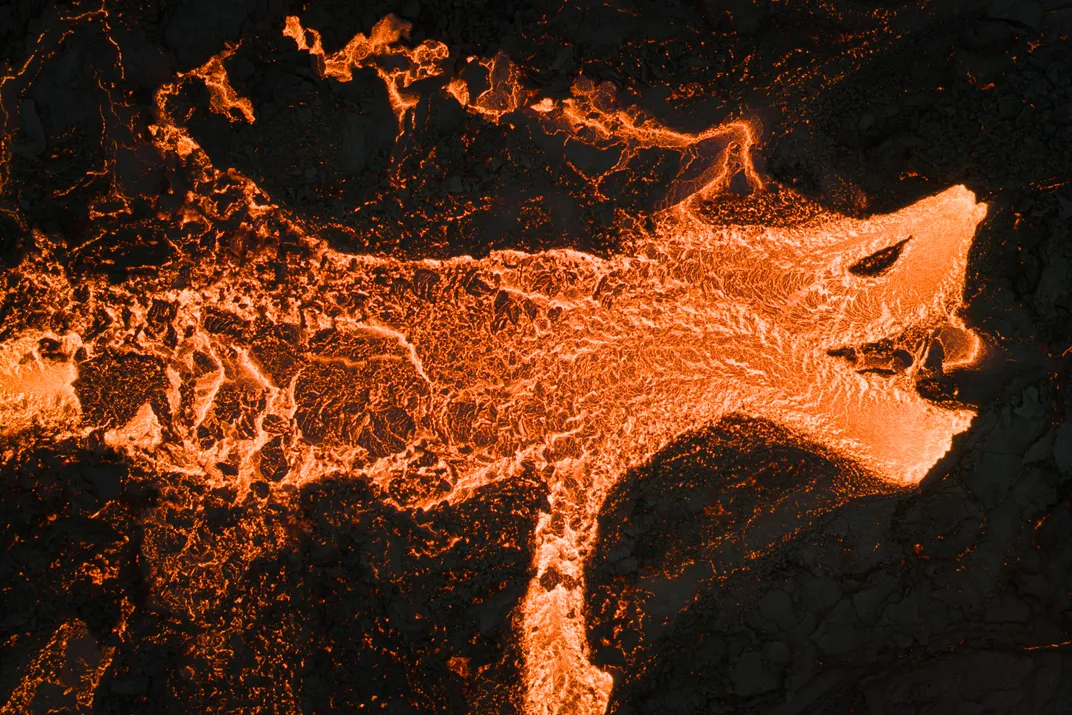 aerial shot of lava that looks to be a creature with a front leg, eye and open mouth with teeth