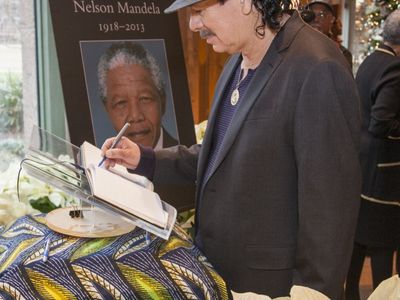 Music Great Carlos Santana signs a condolence book for Nelson Mandela on Dec. 6 at the National Museum of African Art.
