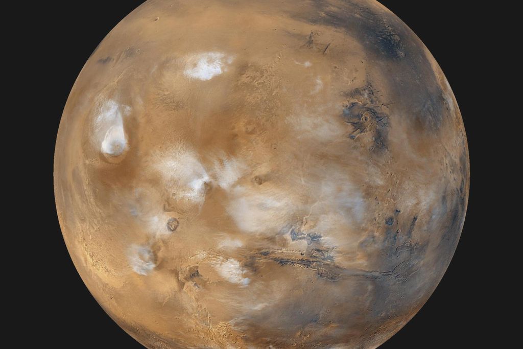The entire planet Mars seen from space with bluish-white water ice clouds above volcanoes