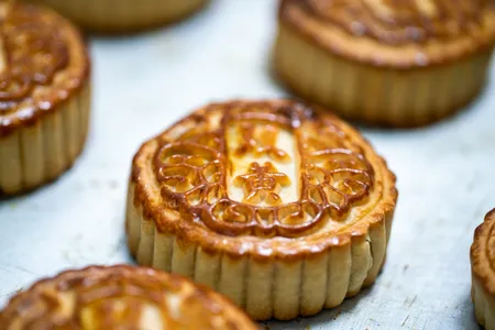 The miniature cakes, which fit in the palm of a hand, are most commonly made with a thin pastry layer encasing a dense filling of sweetened red beans, melon pur&eacute;e or mixed nuts.