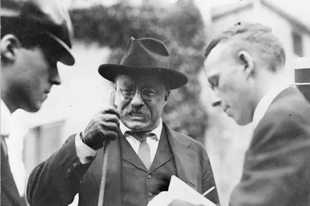 President Theodore Roosevelt clenches his teeth as he makes a point during an interview with unidentified journalists.