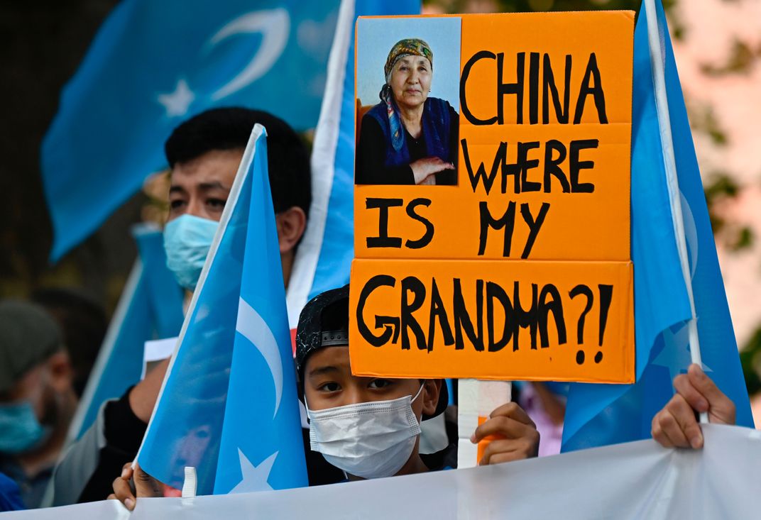 A young Uyghur activist holds a poster that reads "China where is my grandma?!" during a demonstration in Berlin on September 1, 2020.