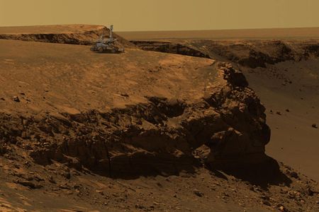 An  artist's concept of the Mars Exploration Rover Opportunity superimposed on a photo of Victoria Crater, taken by the rover. 