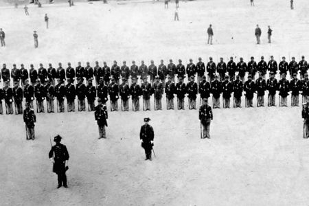 Company H of the 48th New York Regiment, stiffly posed for this 1863 formal portrait at Fort Pulaski, in Savannah, GA, seems oblivious to the more informal baseball game in progress behind them.  The photo is one of the ealiest known photographs of a baseball game.