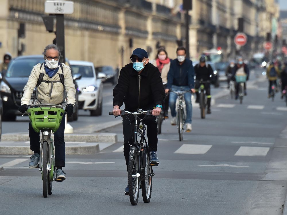 People in France bike wearing masks down the "Rue de Rivoli."