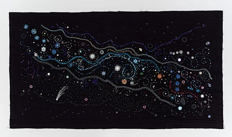A black background with multicolored beads depicts the night sky