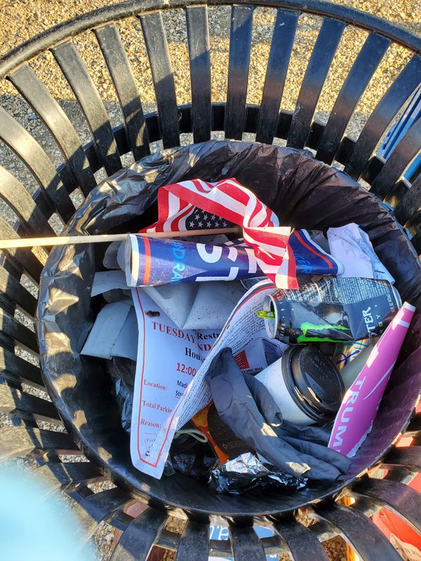 A trash can filled with signs and other ephemera