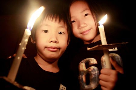 A Malaysian boy and girl holding candles during the 60 minute Earth Hour 2012 celebration in Kuala Lumpur, March 31, 2012.
