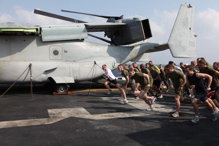 Marines and sailors with 26th Marine Expeditionary Unit and sailors  assigned to USS Kearsarge sprint from the starting line during the "Turkey Trot" 5K  held on the flight deck of USS Kearsarge,  Thanksgiving day,  Nov. 25, 2010. 26th MEU is deployed aboard the ships of the Kearsarge Amphibious Ready Group in the 5th Fleet area of responsibility and acting as the theater reserve force. (Official USMC photo by Lance Cpl. Tyler Logsdon/ Released)