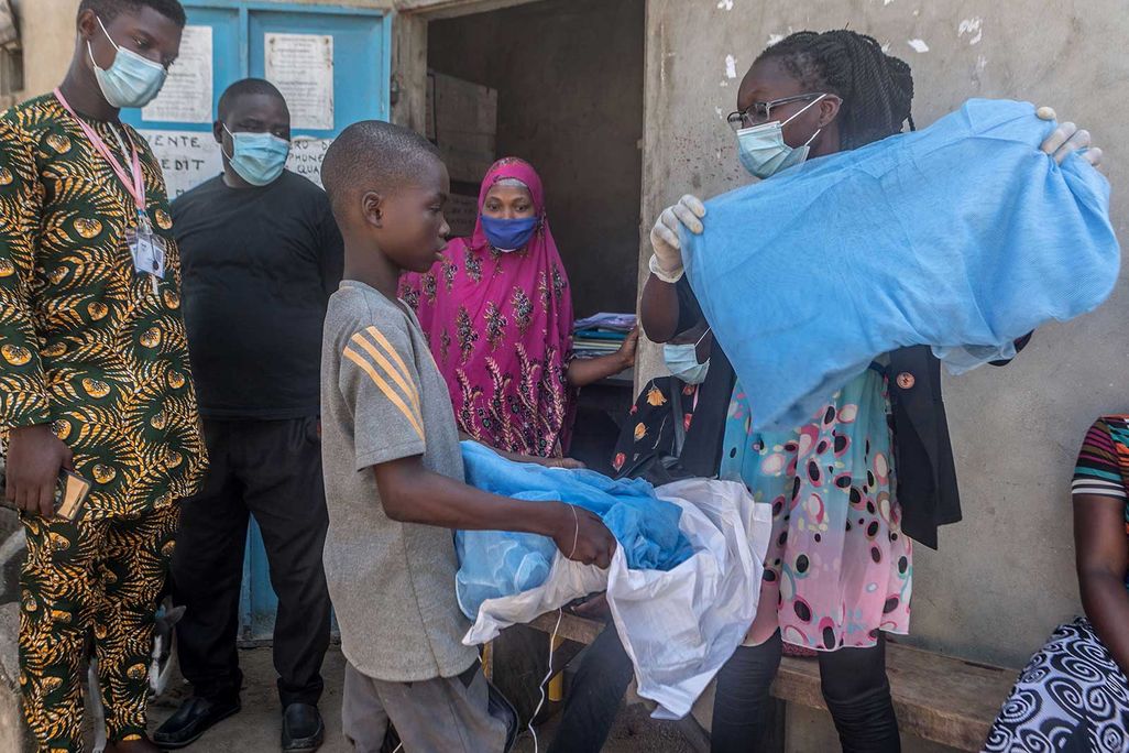 Handing out bed nets in West Africa