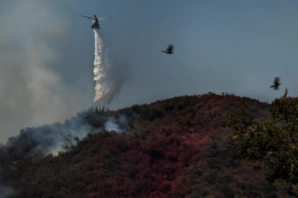 Firefighters in helicopters battle a 1,300 acre brush fire in Pacific Palisades on May 17.