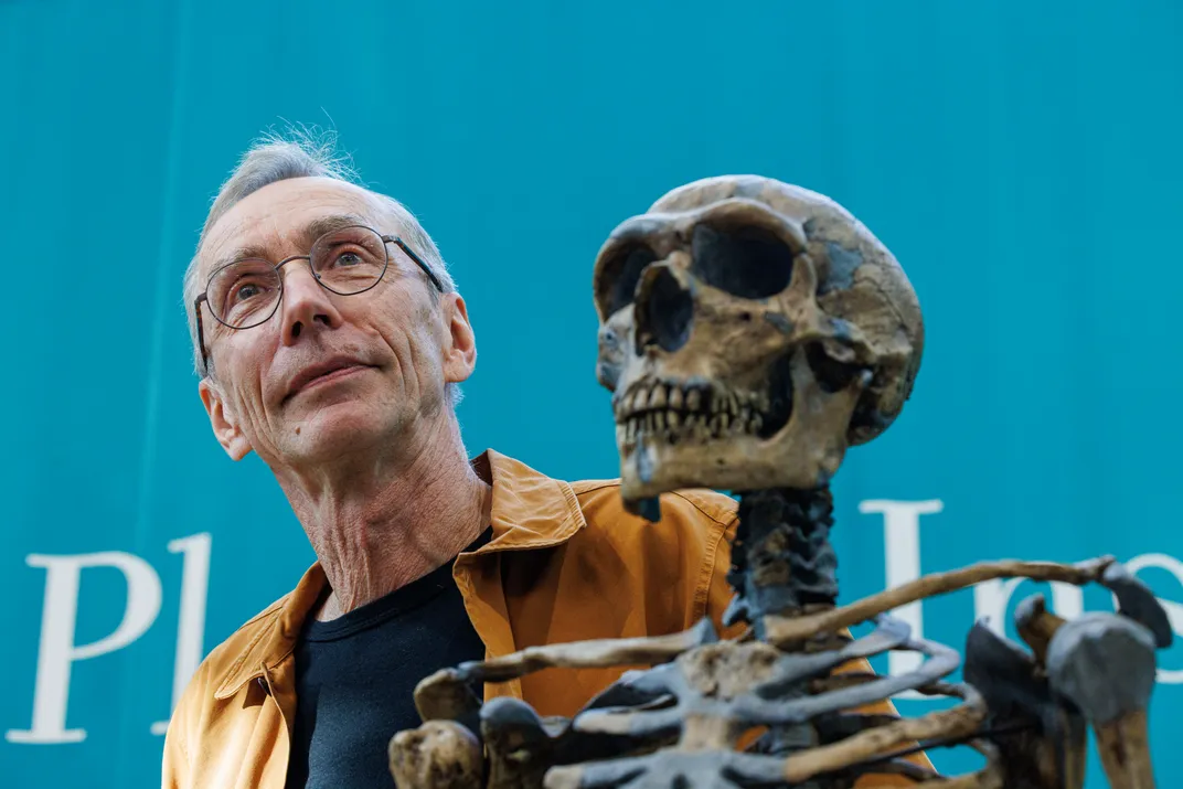 man stands behind a skeleton