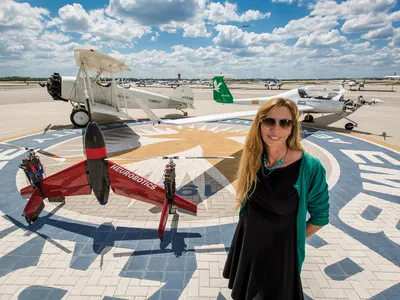 Embry-Riddle professor Carolina Anderson with three generations of aircraft on campus. The daughter of a pilot, she flies her own daughters to work with her, hoping to nurture a third flying generation in her own family.