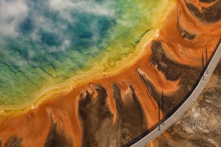 Visitors cast shadows on the Grand Prismatic Spring in Yellowstone National Park, Wyoming, at sunrise.