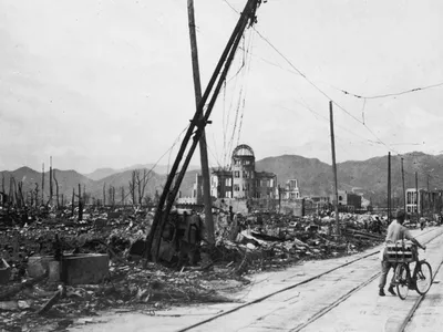 A man wheels his bicycle through Hiroshima days after an atomic bomb leveled the city.