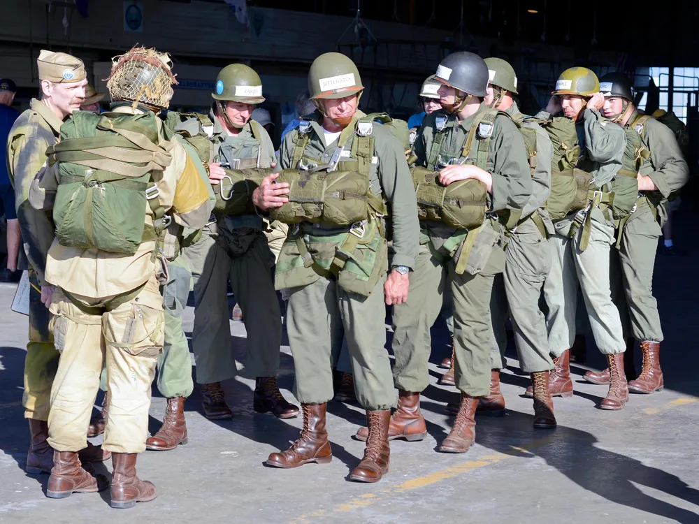 Men in green WWII-remniscent uniforms gather