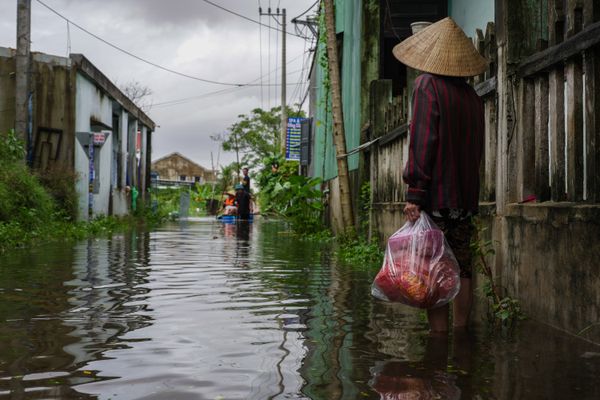 Vietnamese woman waits for a raft during Hoi An floods thumbnail