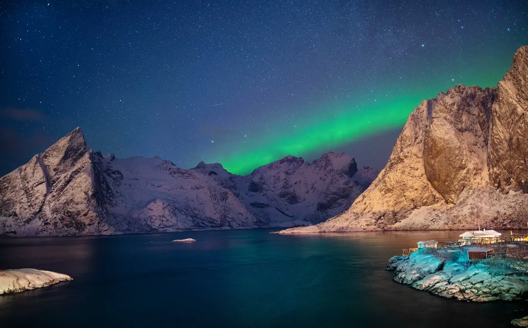 snowy mountain peaks on the water at night