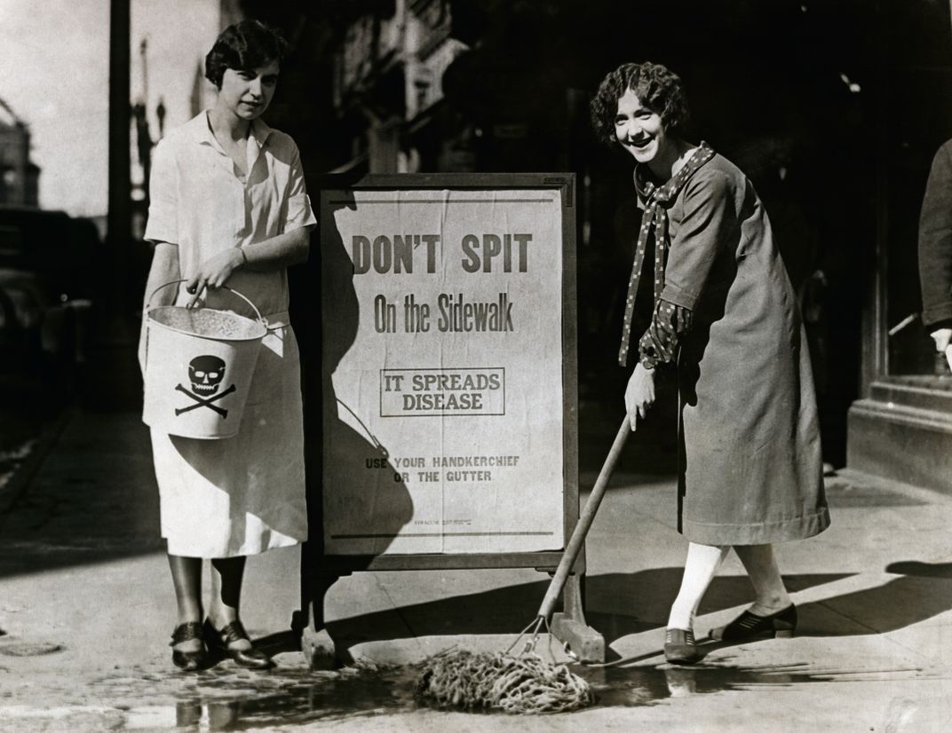 Anti-spitting advocates Allene Goodenough (left) and Helyn James (right) clean up spit on a sidewalk in Syracuse, New York, in 1900.