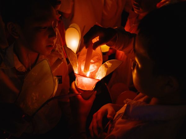 Boys relight their candles during the festival of the boats of light thumbnail
