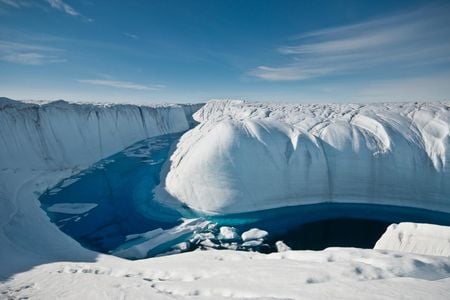 A stream of meltwater cuts through the Greenland ice sheet.


