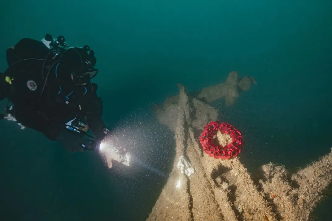 Diver Ricardo Constantino laying a wreath on the tiller of the Tiger