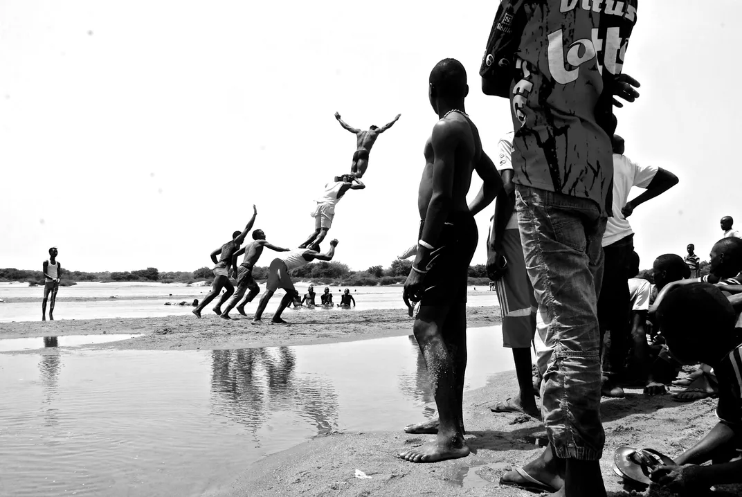 Black and white photo of African people jumping at beach